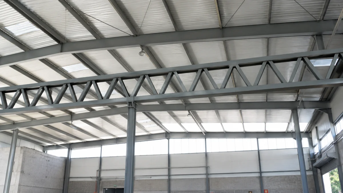 Viga treliçada metálica em galpão industrial — banzos superior e inferior conectados por diagonais e montantes triangulados